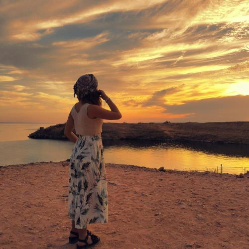 a woman standing on the beach watching the sunset at Safari Abu Simbel in Abu Simbel