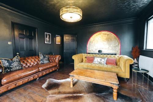 a living room with a couch and a table at House with a cinema and games room, sleeps 17 in Shrewsbury
