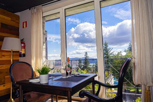 a dining room table with a view of a balcony at Hotel Arcipreste de Hita - Adults Only in Navacerrada