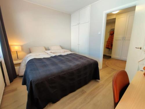 a bedroom with a bed with a blue blanket on it at Room Aria in Savonlinna