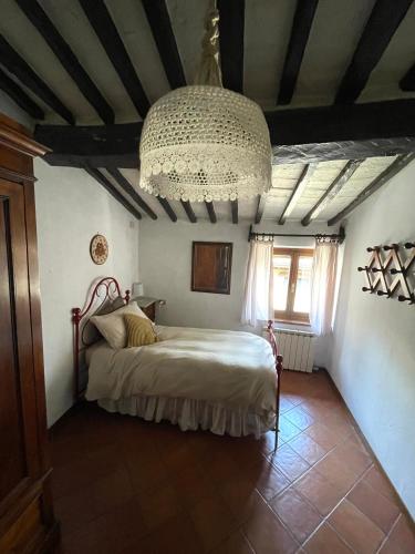 a bedroom with a bed and a chandelier at Borgo la Ruga - Tuscany Home in Chianni