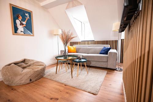 ein Wohnzimmer mit einem Sofa und einem Tisch in der Unterkunft Moderne T2 Centre Sauna Wifi Home office Netflix in Straßburg