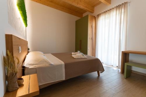 um quarto com uma cama e uma grande janela em Fienilemare casa vacanze em Roseto degli Abruzzi