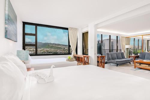 - une chambre avec un lit blanc et une grande fenêtre dans l'établissement Beautiful Renovated Mountain View Condo with Parking!, à Honolulu