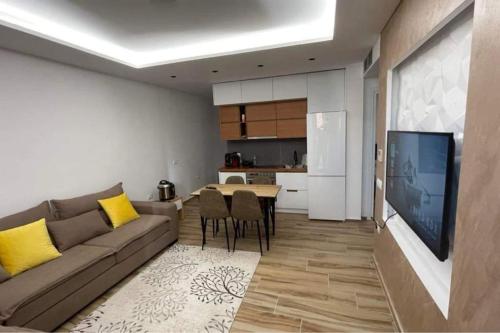 a living room with a couch and a table and a kitchen at Entire holiday flat in Sarande in Sarandë