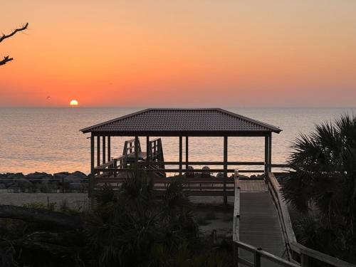 a gazebo on the beach with the sunset in the background at VILLA 315 - The Eagles Nest condo in Jekyll Island