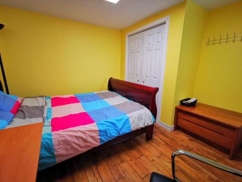 um quarto com uma cama colorida e piso em madeira em one queen-sized bed convenient location em Toronto