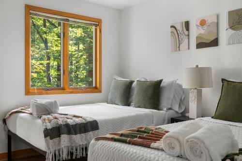 Cette chambre blanche dispose de deux lits et d'une fenêtre. dans l'établissement The Tree House in Alexandria VA, Washington DC, à Alexandria