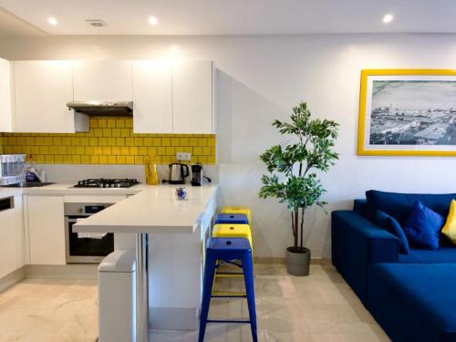 een keuken en een woonkamer met een blauwe bank bij TOP APPARTEMENT GUELIZ in Marrakesh