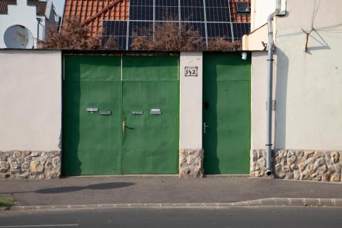 two green doors on the side of a building at Cívis Debrecen Hostel in Debrecen
