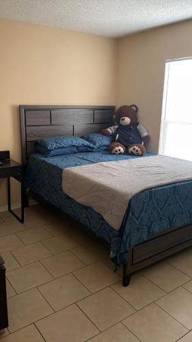 a person laying on a bed with a teddy bear at Comfy room and more in Poinciana