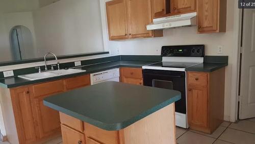 a kitchen with wooden cabinets and a black counter top at Comfy room and more in Poinciana