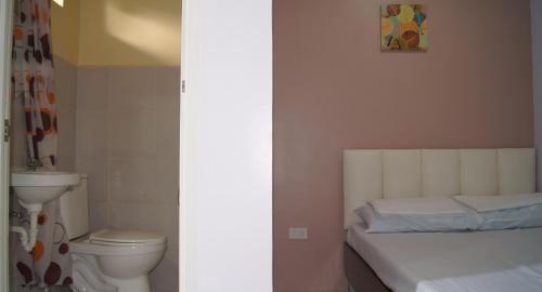 uma casa de banho com uma cama e um WC num quarto em StayLite em Tagbilaran