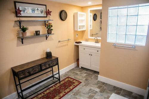 a bathroom with a sink and a mirror and a counter at StockYards! Less than 4 minutes-Sleeps 8-Lee House in Fort Worth