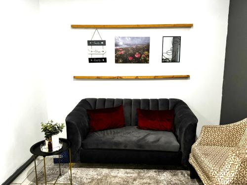 un divano nero in soggiorno con una foto sul muro di Tranquil Living on Maboneng a Johannesburg