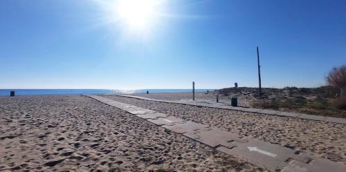 a path on the beach with the sun in the background at Mar & Aventura in Torredembarra