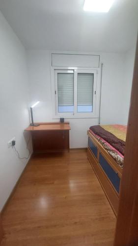 a bedroom with a desk and a bed and a window at Mar & Aventura in Torredembarra