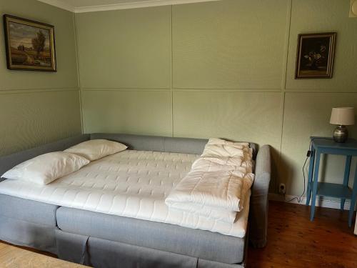 uma cama com lençóis brancos num quarto em Ormanäs Stugby em Höör