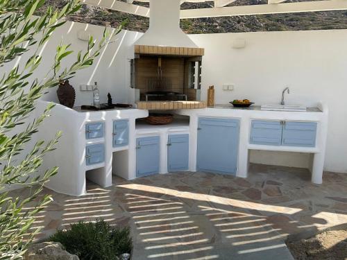 Villa Xanthos في بلاكا: مطبخ مع دواليب زرقاء ومغسلة
