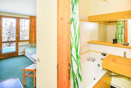 Cet appartement comprend une chambre et une salle de bains pourvue d'un lavabo. dans l'établissement Résidence Le Hameau du Sauget - maeva Home - Studio 4 Personnes Budget MAE-1981, à La Plagne Tarentaise