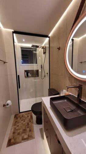 a bathroom with a sink and a toilet and a mirror at Lindo apartamento centro de Floripa in Florianópolis