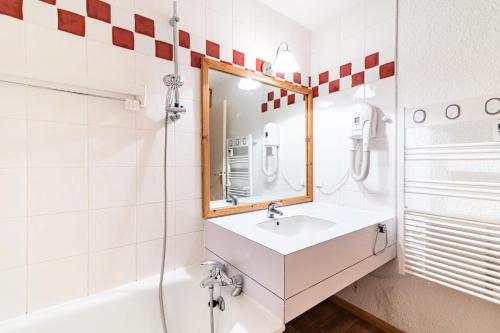 La salle de bains est pourvue d'un lavabo et d'un miroir. dans l'établissement Les Résidences de Valmorel - maeva Home - 2 Pièces 5 Personnes Sélection 01, à Valmorel