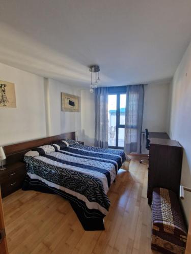 a bedroom with two beds and a window at Castro Urdiales Mioño in Mioño