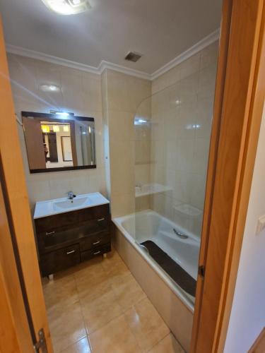 a bathroom with a bath tub and a sink at Castro Urdiales Mioño in Mioño