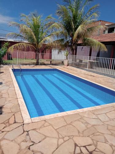 a swimming pool in a yard with palm trees at Chácara do Lele in Ribeirão Preto