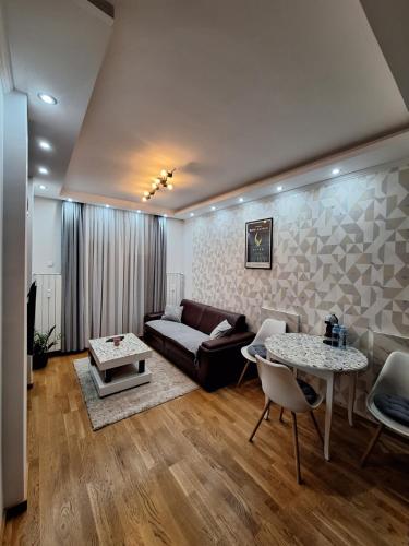 - un salon avec un canapé et deux tables dans l'établissement LUX APARTMENT SANJA 3, à Subotica
