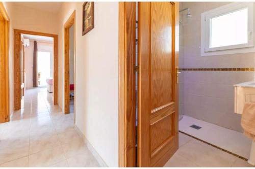 ein Badezimmer mit einer Dusche und einer Holztür in der Unterkunft Cal Llop in L'Escala