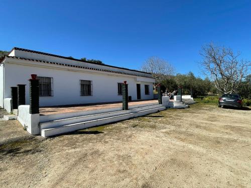 a white building with a car parked in front of it at FINCA SAN RAFAEL in Cabra