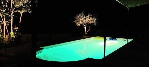 - une piscine avec un arbre en arrière-plan la nuit dans l'établissement La Villa Bellevue Anduze, à Anduze