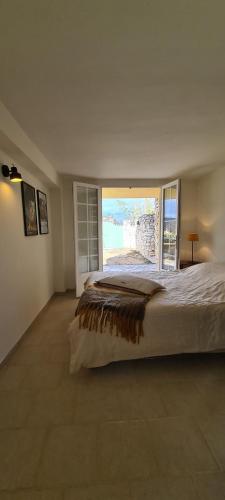 a bedroom with a large bed with a large window at La Villa Bellevue Anduze in Anduze