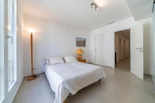 - une chambre blanche avec un lit et une lampe dans l'établissement Very nice 3 bedrooms apartment in the heart of downtown Cannes, à Cannes