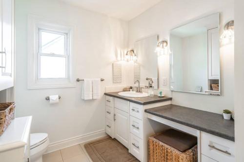 a white bathroom with a sink and a toilet at Boho Inspired NOTL Wine Country Private Home for 2 in Niagara-on-the-Lake