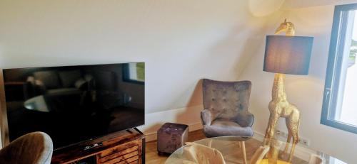 un soggiorno con tavolo in vetro e sedia di LE LOFT a Séné