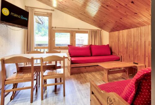 un salon avec un canapé rouge et une table dans l'établissement Quartier Crève Cœur - maeva Home - 2 Pièces 5 Personnes Sélection MAE-3777, à Valmorel