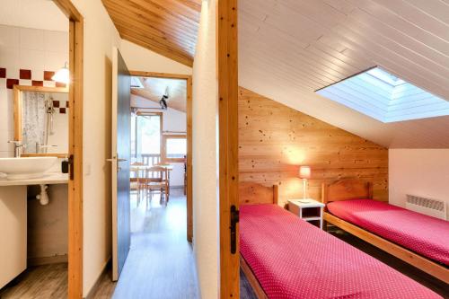 - une chambre avec un lit rouge et un lavabo dans l'établissement Quartier Crève Cœur - maeva Home - 2 Pièces 5 Personnes Sélection MAE-3777, à Valmorel