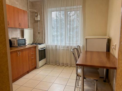 une petite cuisine avec une table et un four micro-ondes dans l'établissement Затишна квартира, центр, ТЦ Мануфактура, à Soumy
