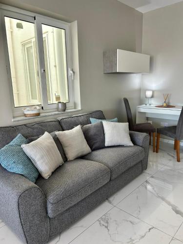 a gray couch in a living room with a table at Modern Cozy & Spacious Apartments in Malta - Perfect Stay Near Saint Julians in Is-Swieqi
