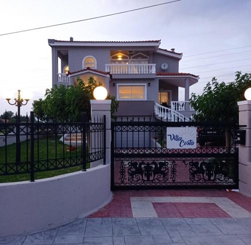 a house with a gate in front of it at Villa Costa in Periyiálion