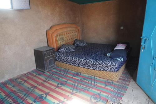 Dormitorio pequeño con cama y fogones en Green Camp Sahara, en Mhamid