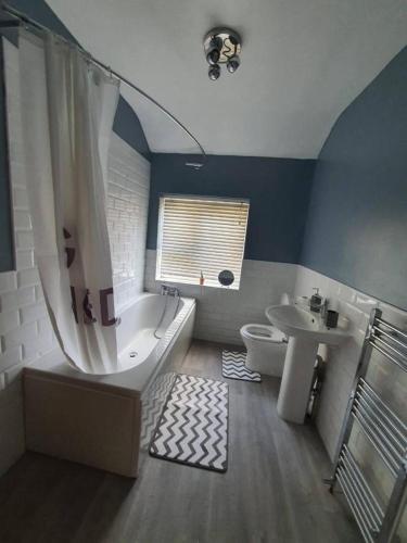 uma casa de banho com uma banheira, um WC e um lavatório. em Double Bedroom 96GLB Greater Manchester em Middleton