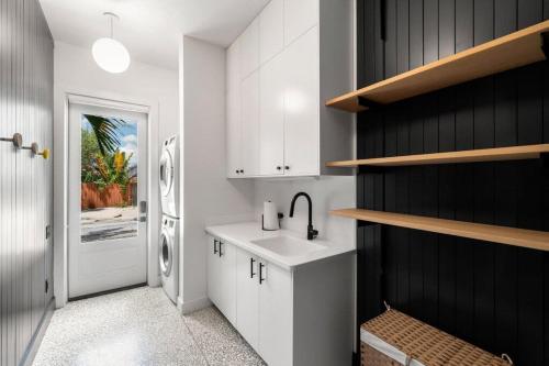 a kitchen with a sink and a refrigerator at Casa Cohiba - Ybor City Townhouse in Tampa