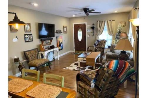 a living room filled with furniture and a table at StockYards!-1 block away ! Cowboy Cottage sleeps 9 in Fort Worth