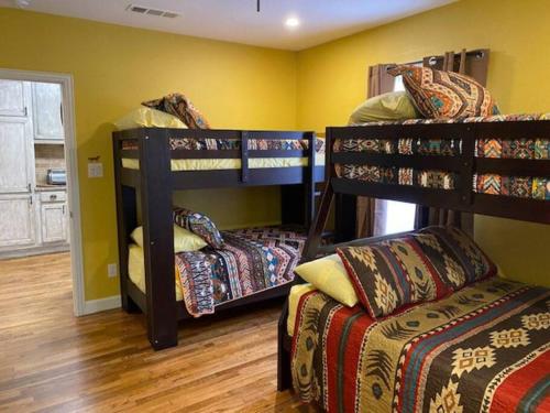 Cette chambre comprend 3 lits superposés et un canapé. dans l'établissement StockYards!-1 block away ! Cowboy Cottage sleeps 9, à Fort Worth