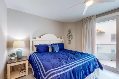 een slaapkamer met een blauw bed en een raam bij Silver Beach 601 in Orange Beach