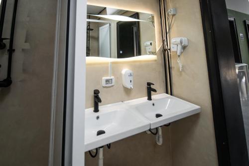 a white sink in a bathroom with a mirror at Shkodra Hostel in Shkodër