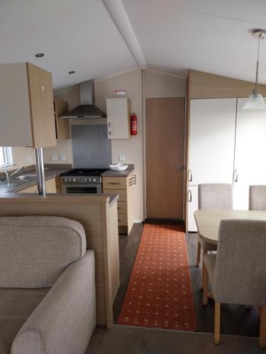 a kitchen and dining room with a table and chairs at Cordy's Caravan in Mablethorpe